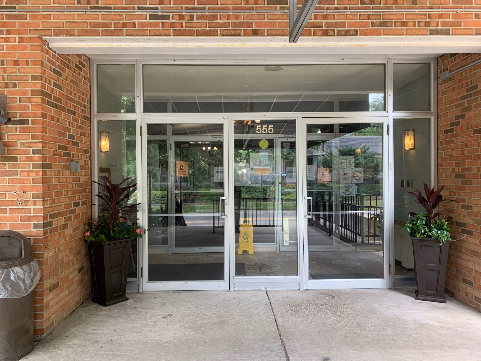 Entrance to Arcadia Care on the Hill, brick front with glass doors and potted plants.