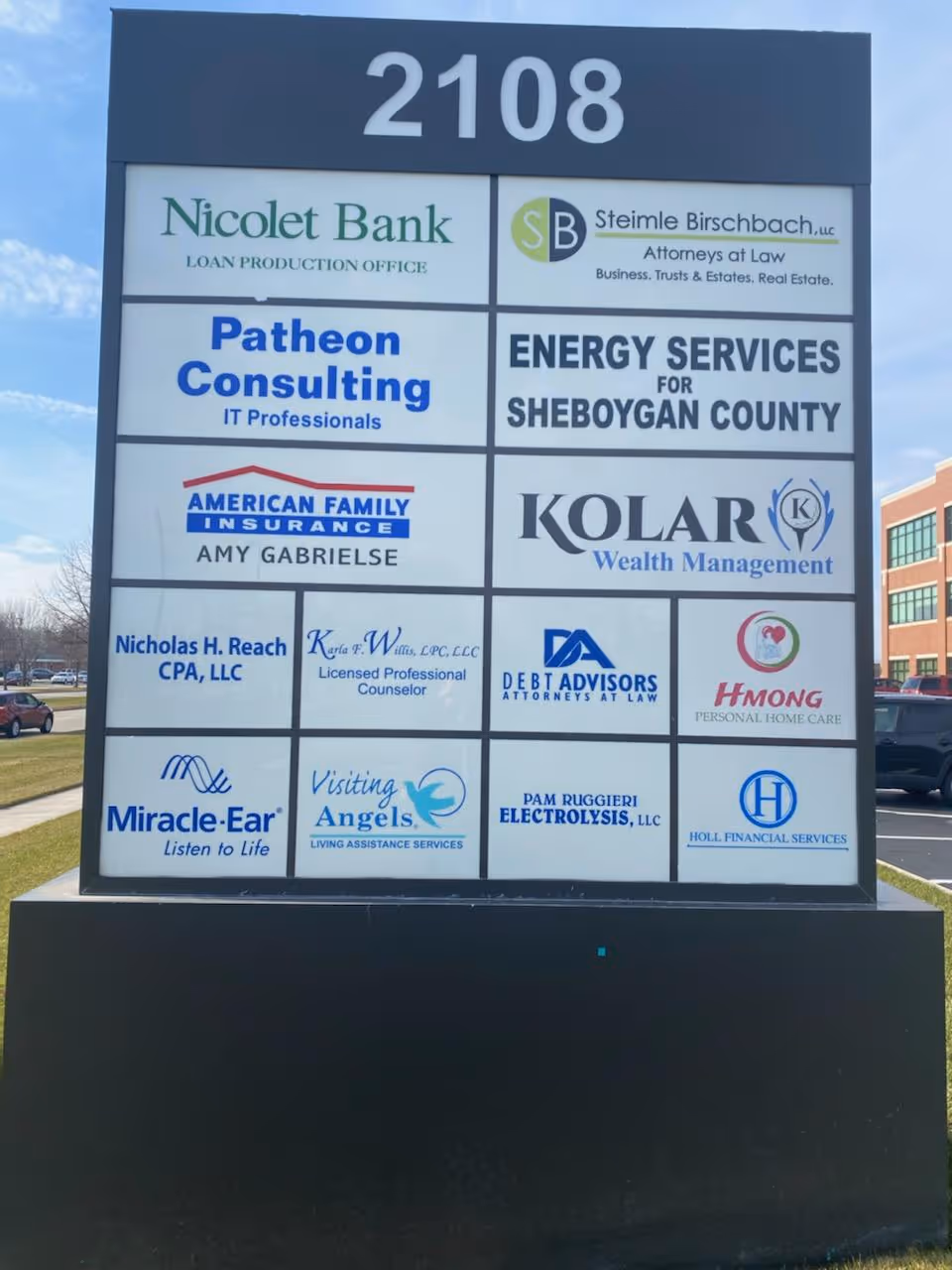 Outdoor signboard featuring Visiting Angels Senior Home Care Sheboygan among many business logos
