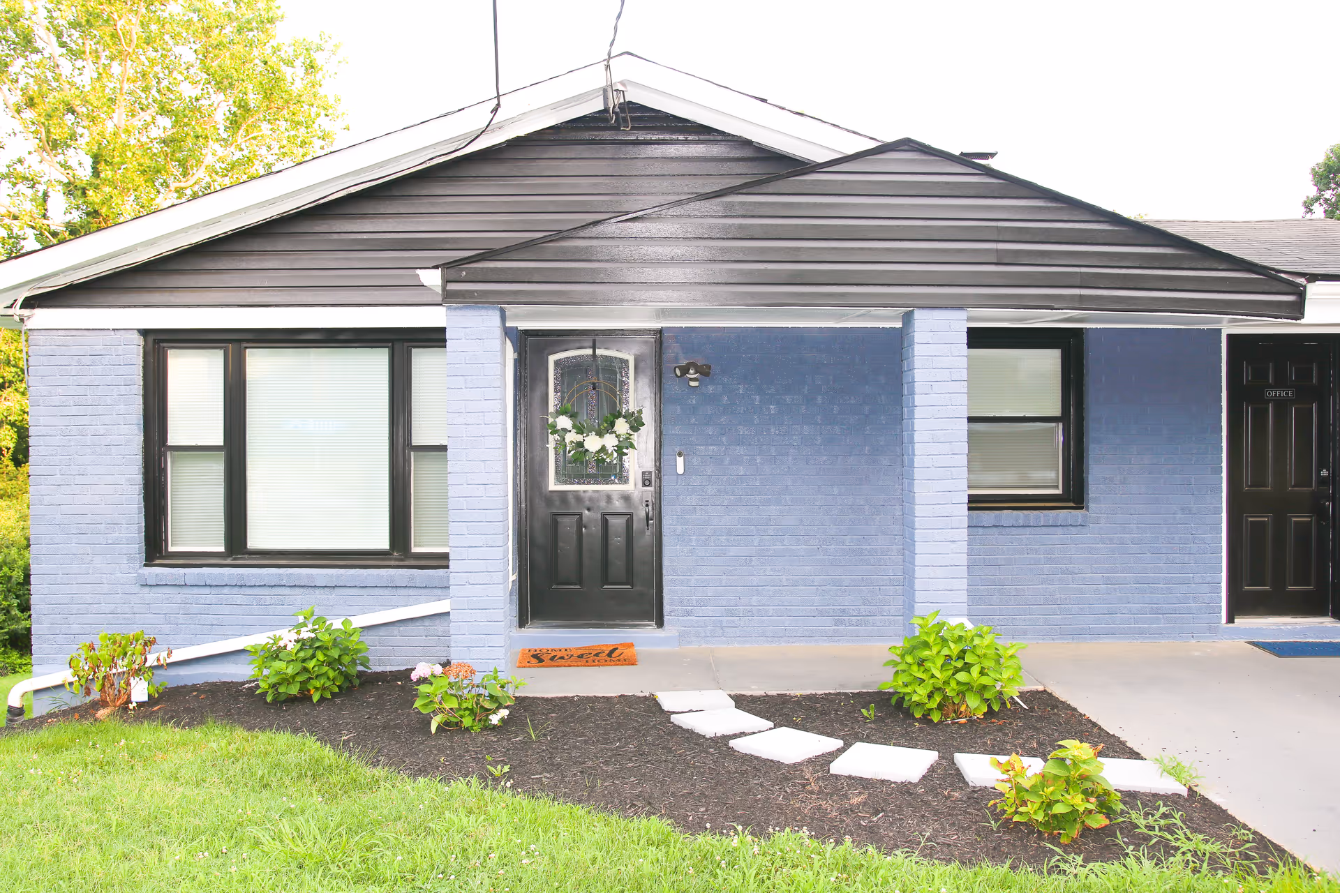 Blue brick exterior of a single-story assisted living facility with front entrance.