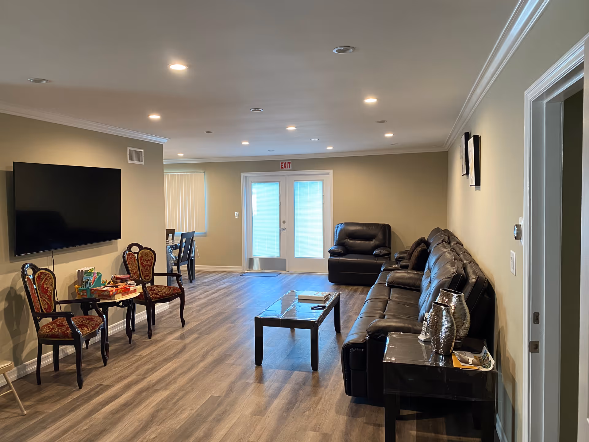 Spacious Chatsworth Living common area with leather sectional, chairs, coffee table, and wall-mounted TV.