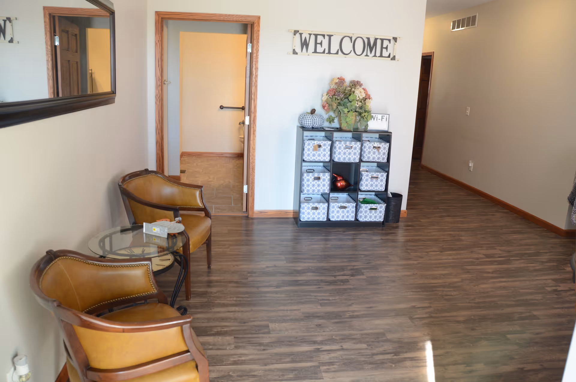 Lobby area of a senior care facility with chairs, welcome sign, and storage cubbies.
