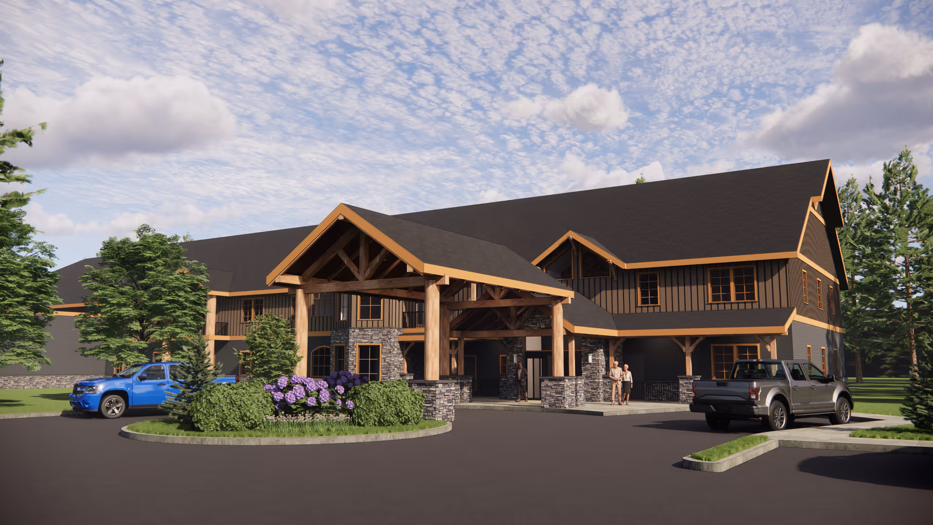Exterior view of a two-story senior living facility building with a large covered entrance supported by wooden beams and stone pillars. There are two pickup trucks parked near the entrance, landscaped greenery including bushes and trees, and a partly cloudy sky overhead.