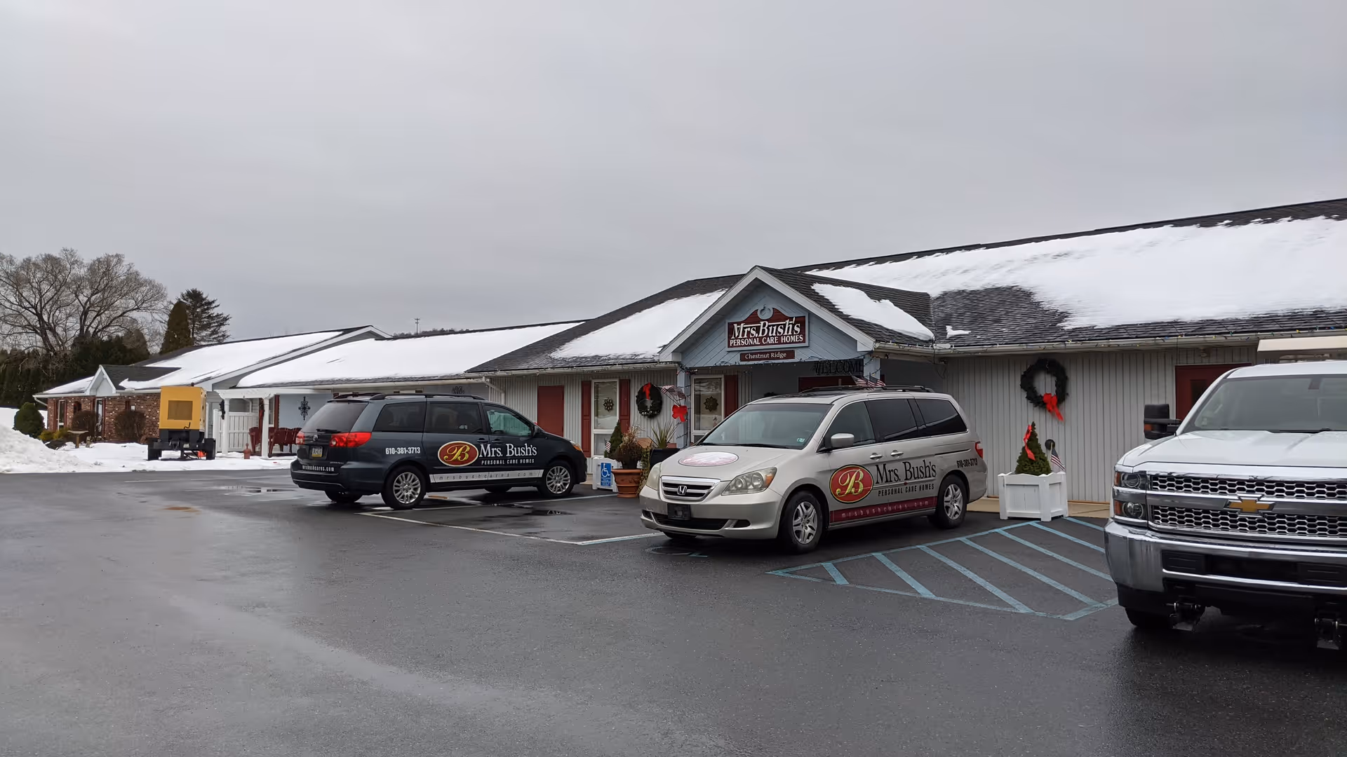 Snowy exterior of Mrs Bushs Personal Care Homes with parked cars in front