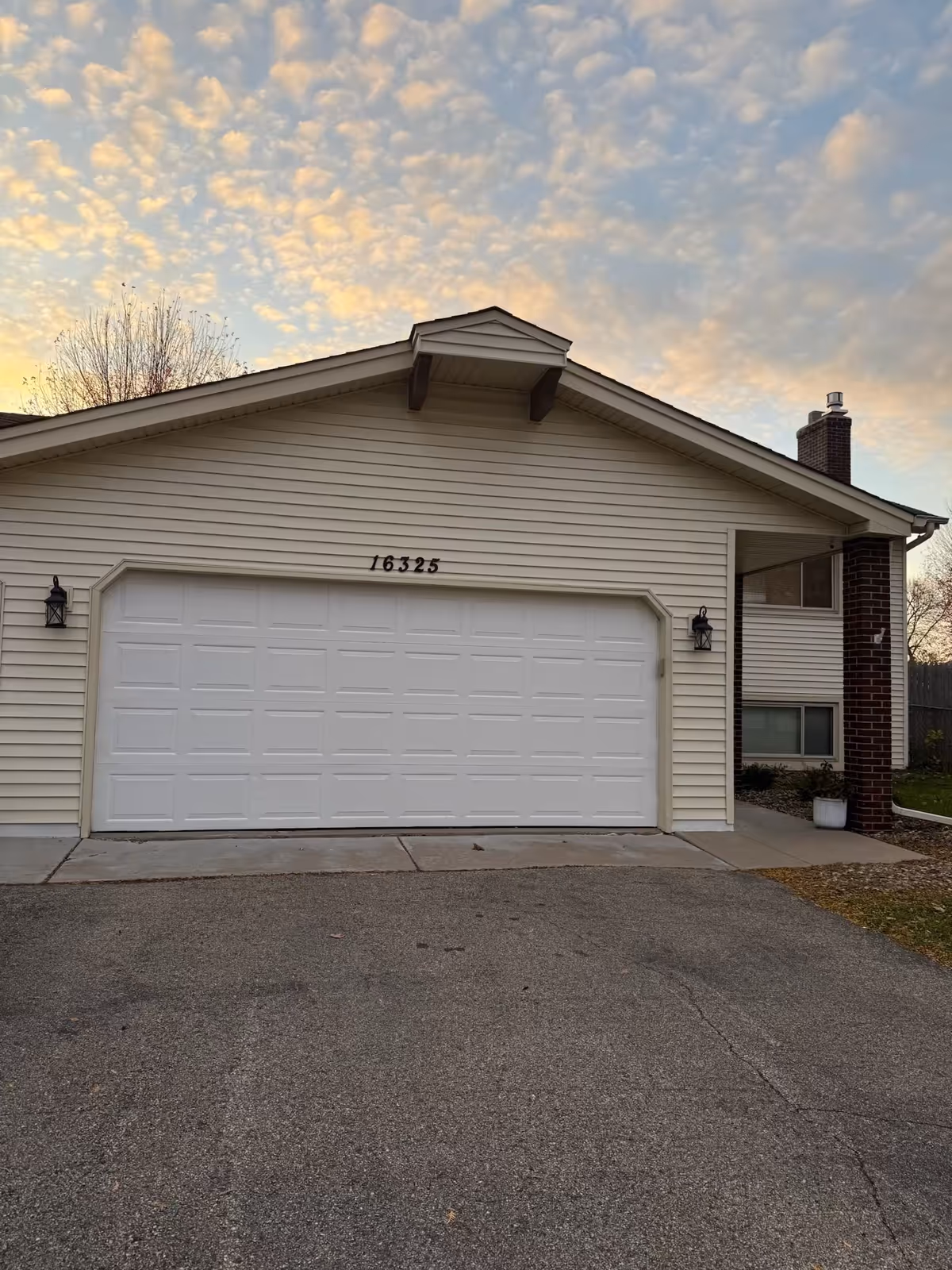 Front view of a beige senior living facility with a white garage door