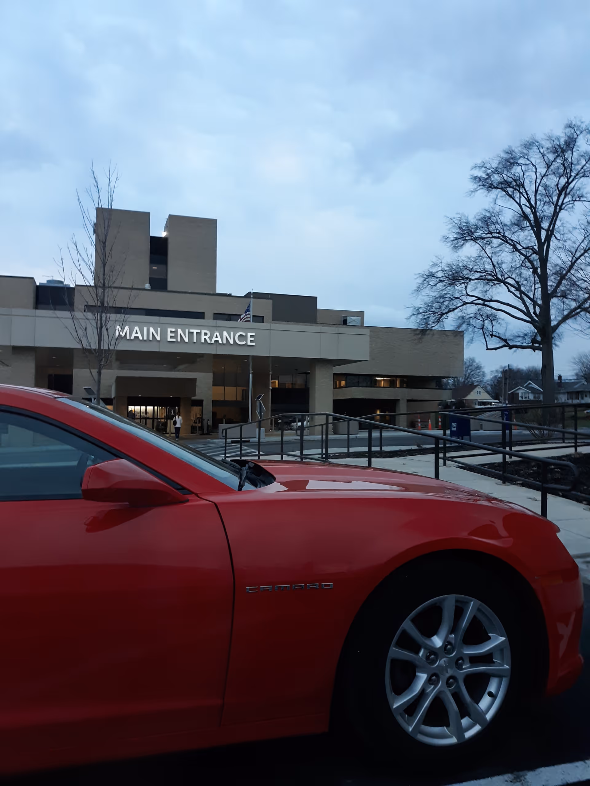 Red car parked in front of Saber Skilled Nursing Unit at Barberton main entrance.