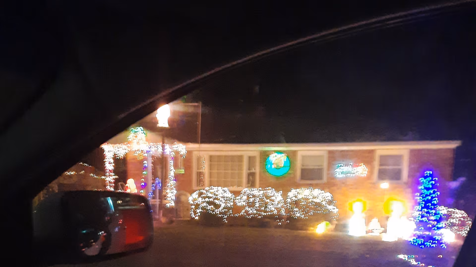 Nighttime exterior view of Caring Hearts facility with colorful holiday lights and decorations.