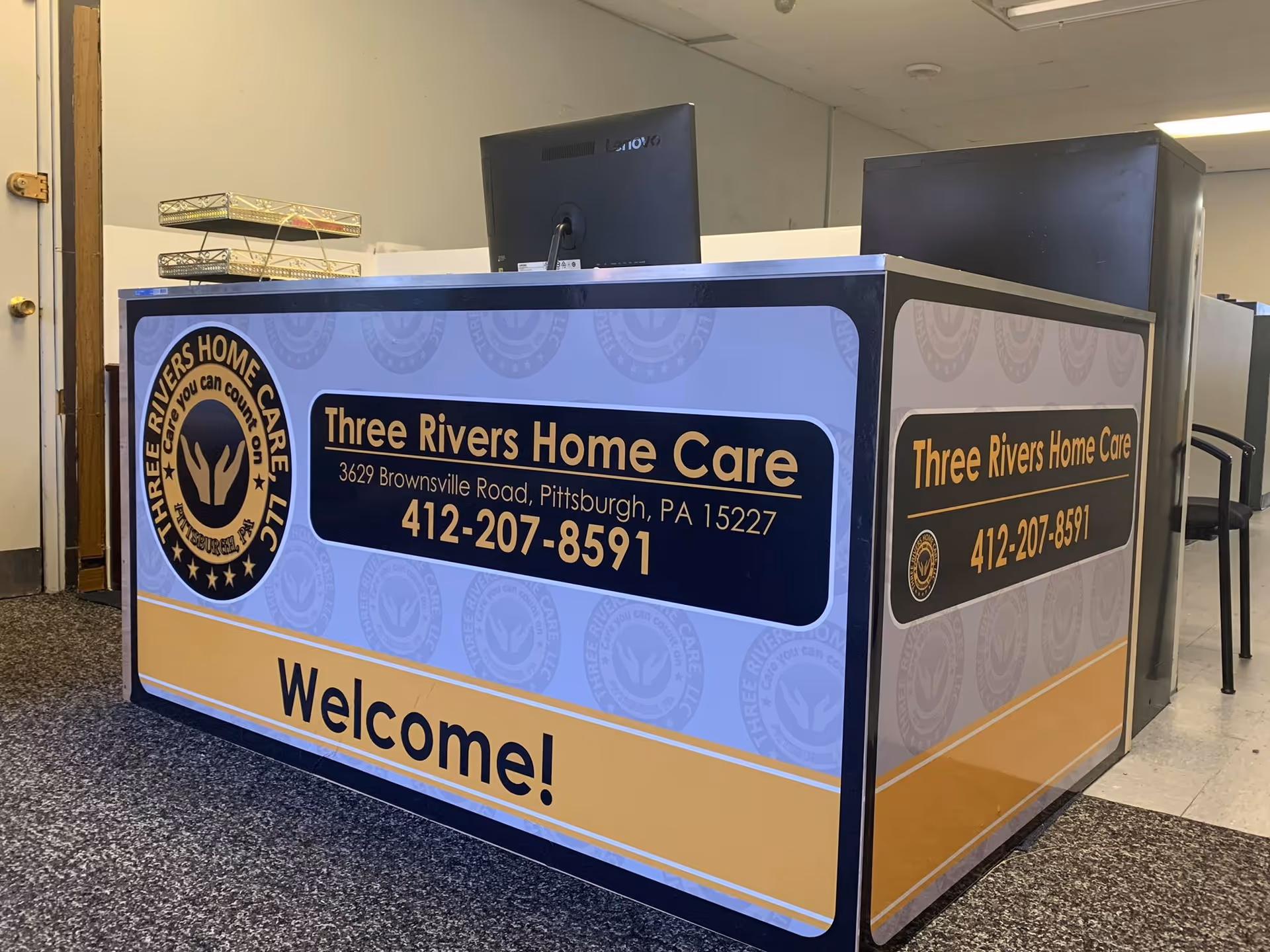 Front desk with Three Rivers Home Care branding inside a facility lobby.
