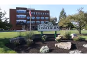 Exterior view of The Gardens by Morningstar building with landscaped front yard and sign.