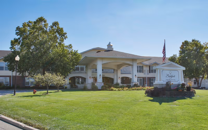 Exterior view of Bickford of Bloomington with entrance and landscaped lawn.