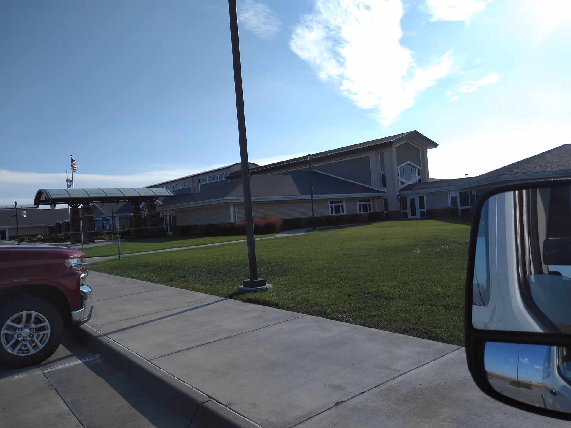 Exterior view of Stevens County Hospital LTCU Pioneer Manor with lawn and parking.