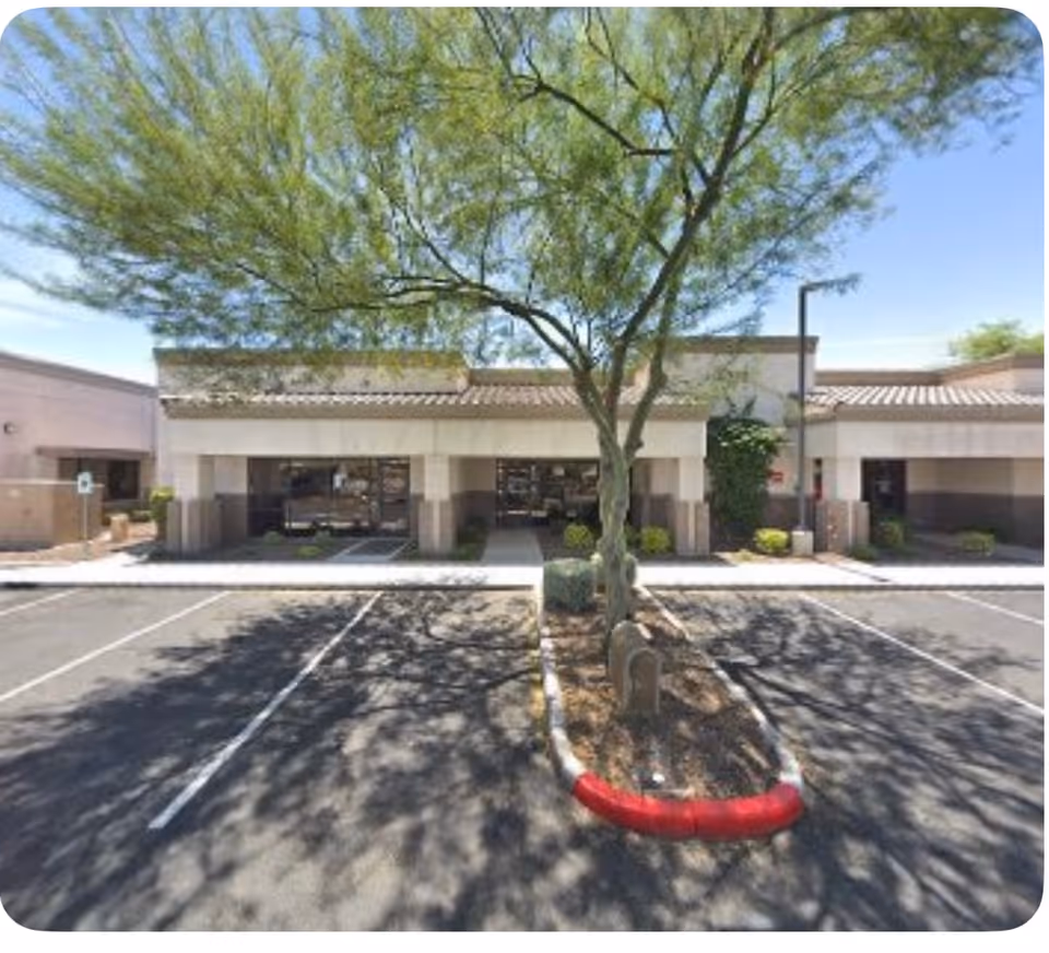 Exterior view of Senior Helpers Glendale, AZ building with entrance, parking, and a central tree.