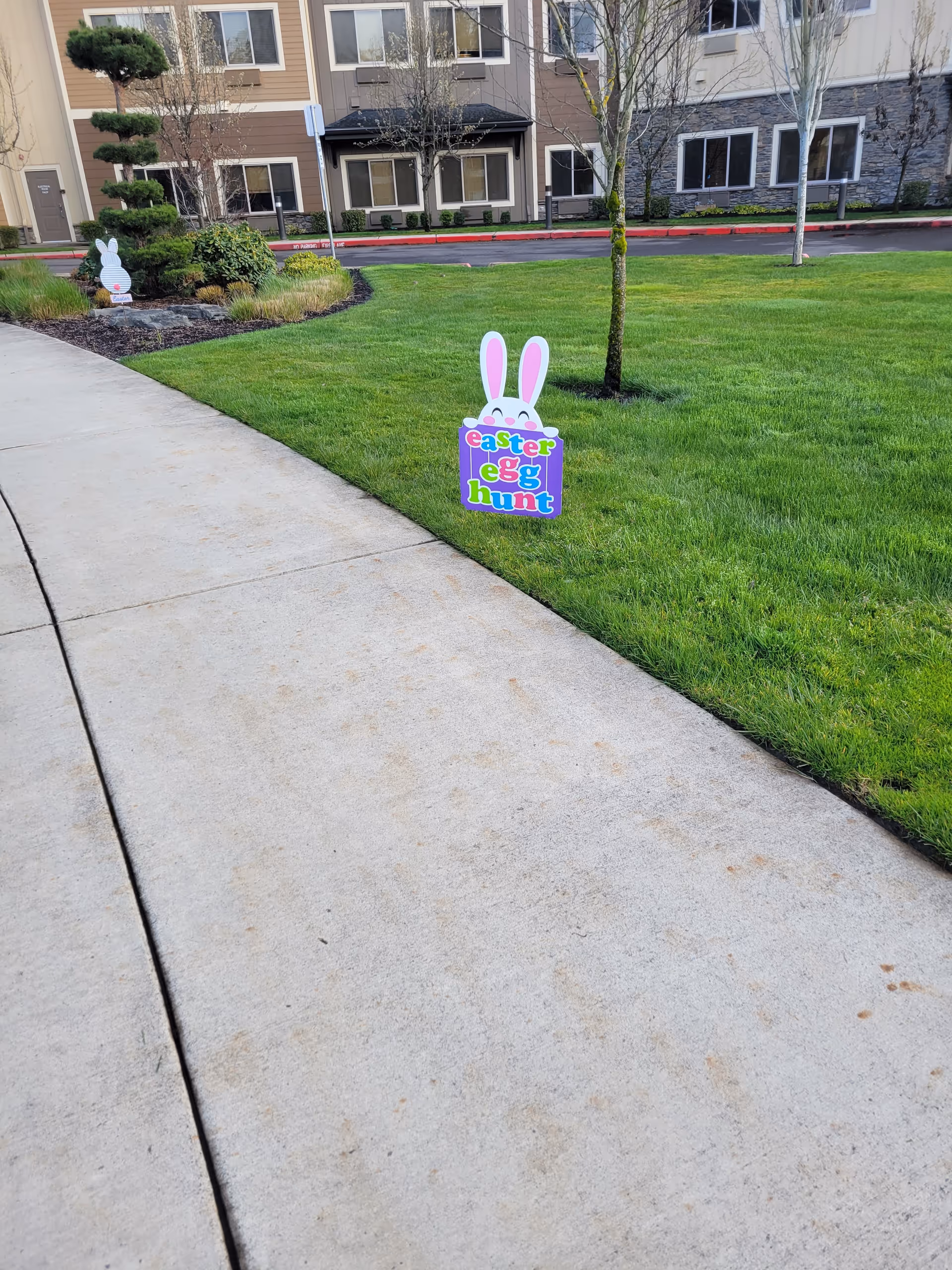 Exterior view of a senior living campus lawn with Easter egg hunt signs