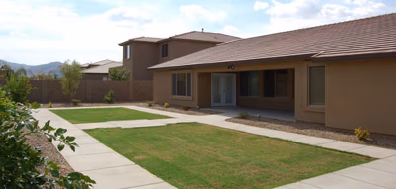 Exterior of a single-story assisted living building with a grassy courtyard.