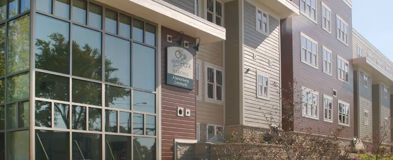 Exterior view of Oak Park Place Nakoma senior living building with entrance sign.
