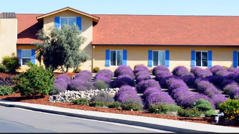 Front view of Lavender Hills Assisted Living III building with purple flowering shrubs.