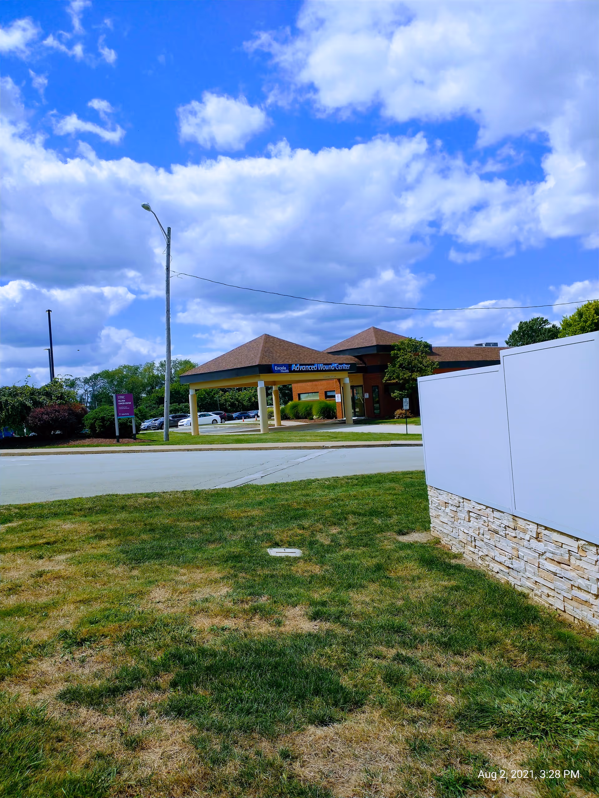 Front entrance of Independence Health Frick Hospital with a covered entrance, parking lot, and blue sky.