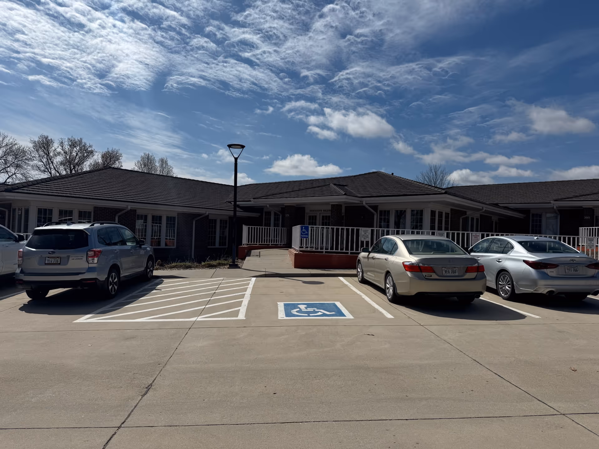 Front view of a single-story brick senior facility with handicap parking.
