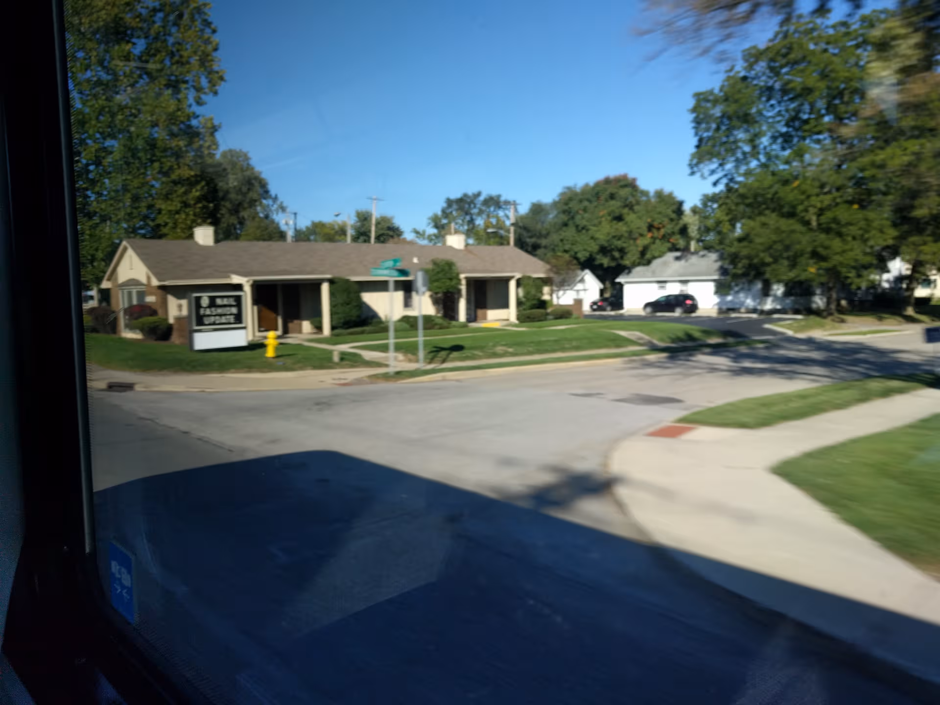 A single-story beige nursing facility viewed from the street with a front sign.