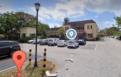 Exterior view of Harmony Health Center with parked cars and a street lamp in front.