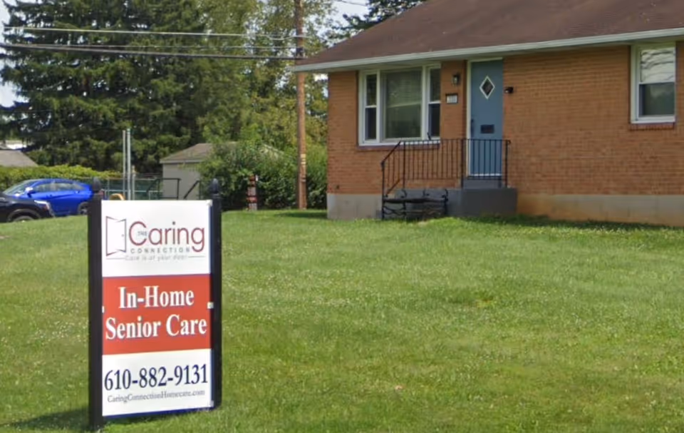 Brick building with a grassy lawn and an In-Home Senior Care sign.