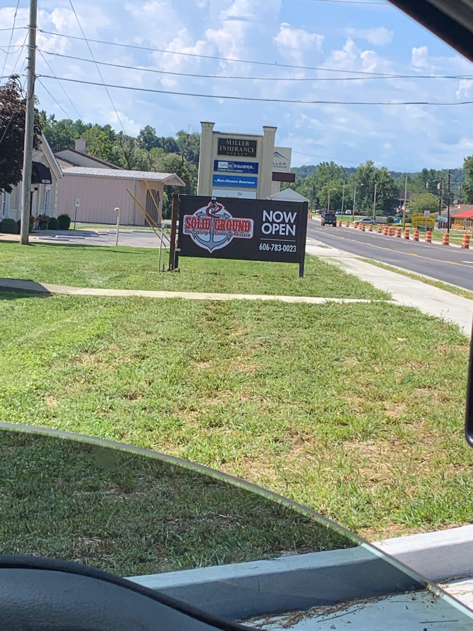Roadside view of a Solid Ground Counseling & Recovery Centers sign by a building.