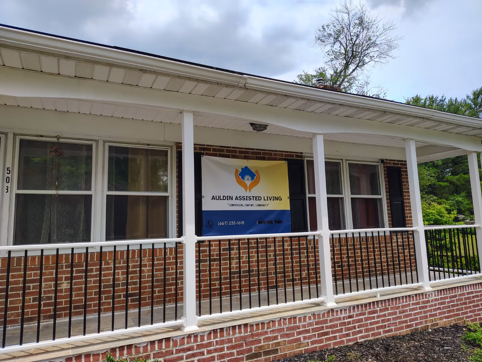 Brick building with a covered porch and Auldin Assisted Living banner.