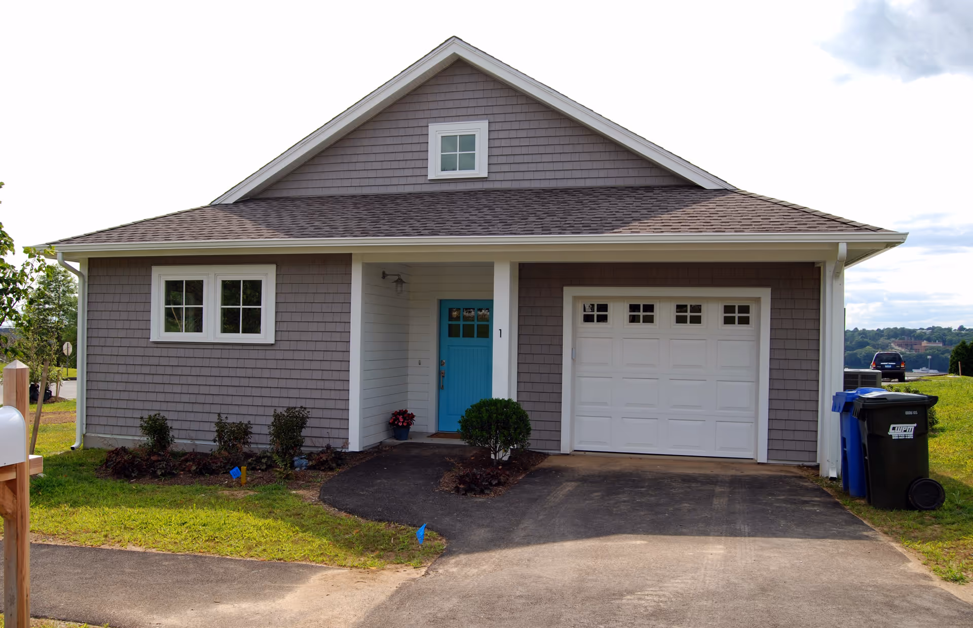Front view of Fairview senior living facility with gray siding and blue door.