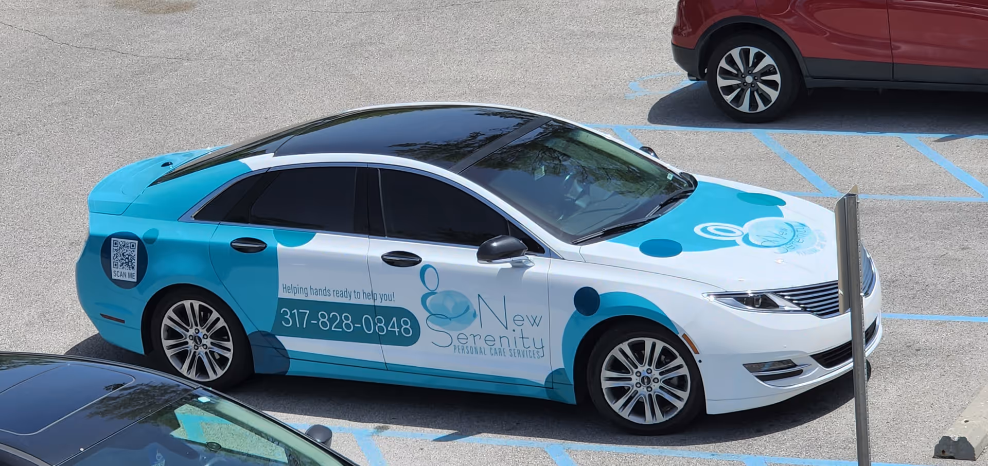 Branded sedan with New Serenity Personal Care Services livery parked in a handicapped space.