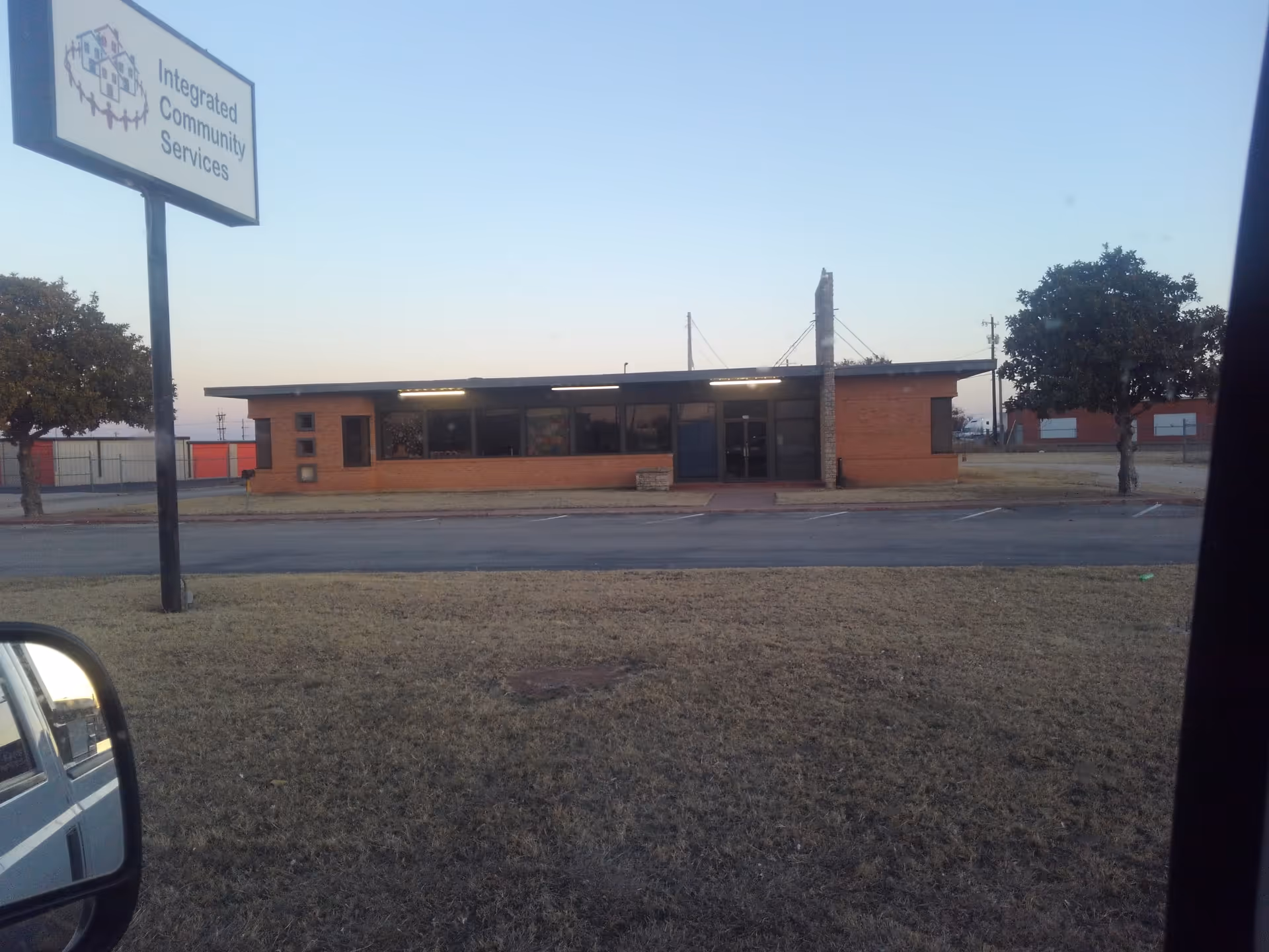 Brick, single-story building with Integrated Community Services sign in a parking lot.