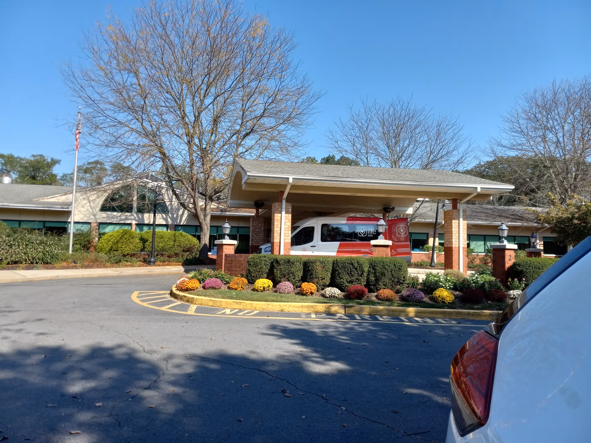 Exterior view of Complete Care at Park Place entrance with a covered drop-off and landscaped circle.