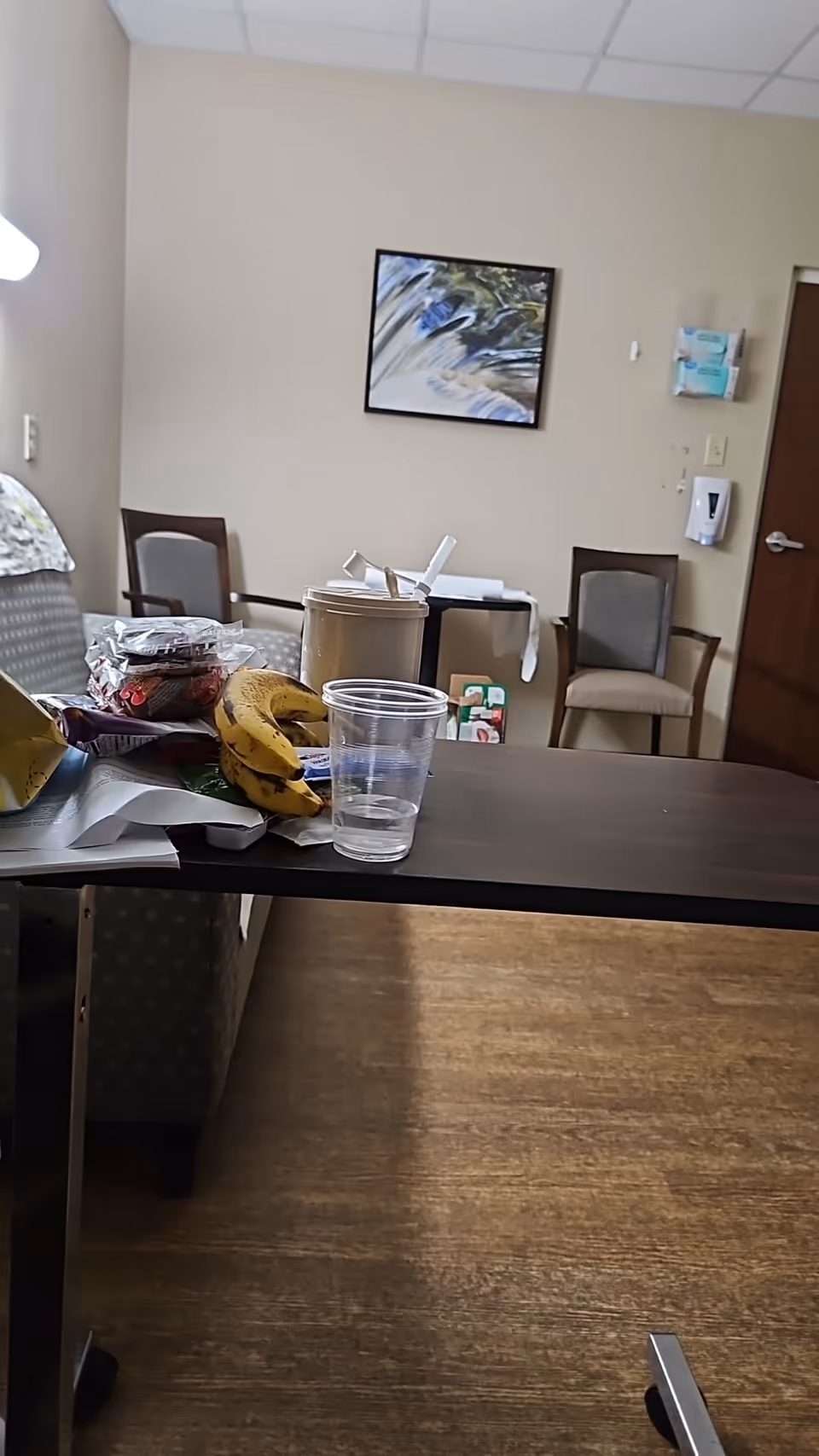 Common dining area in a senior facility with a table, chairs, and scattered snacks.