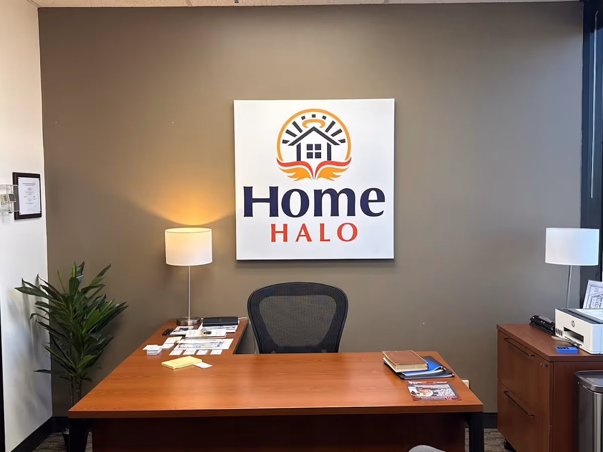 Reception desk in an office area with a Home Halo logo on the wall.