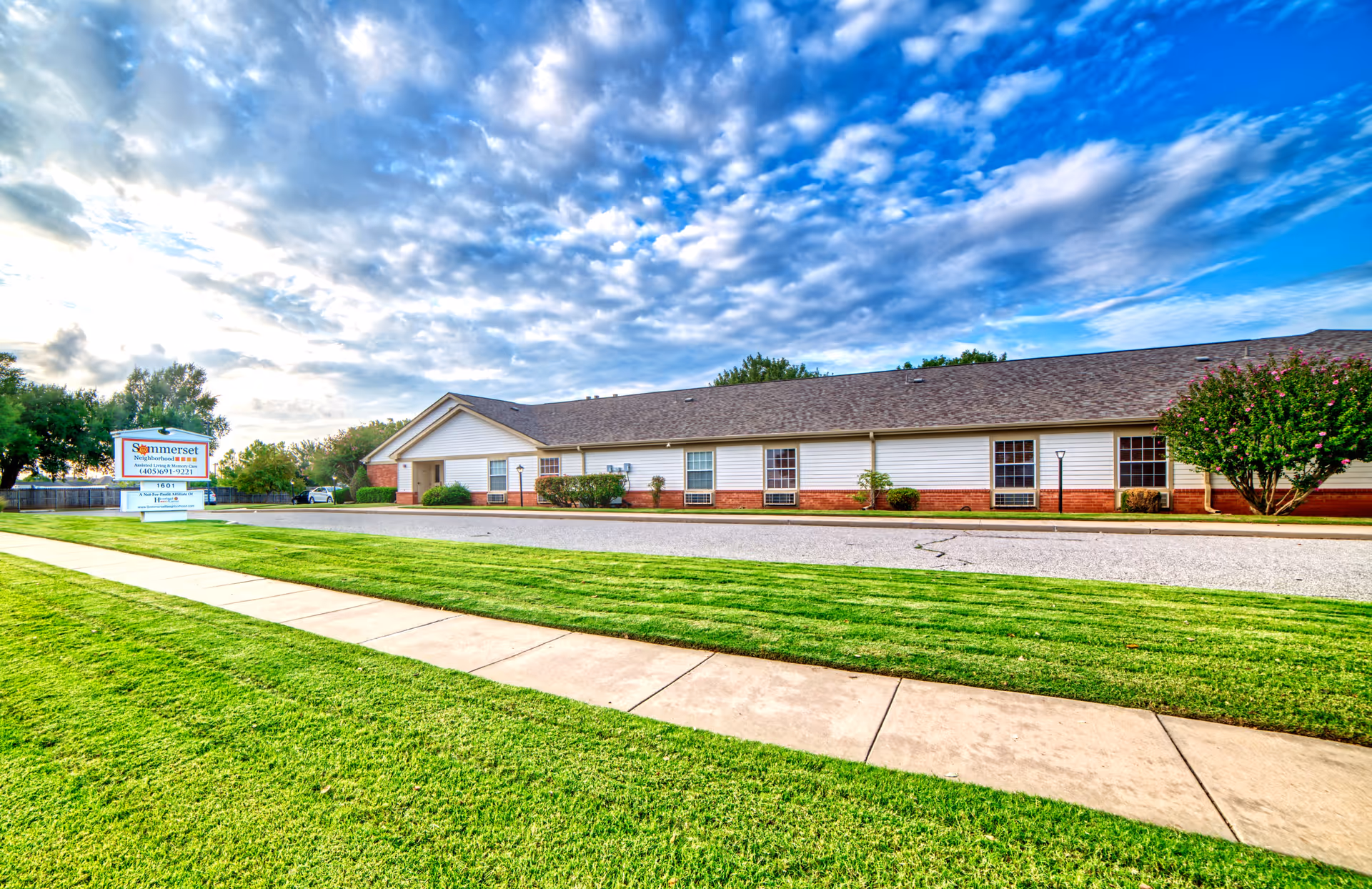 Exterior view of a single-story Somerset Neighborhood facility with manicured lawn and sign.