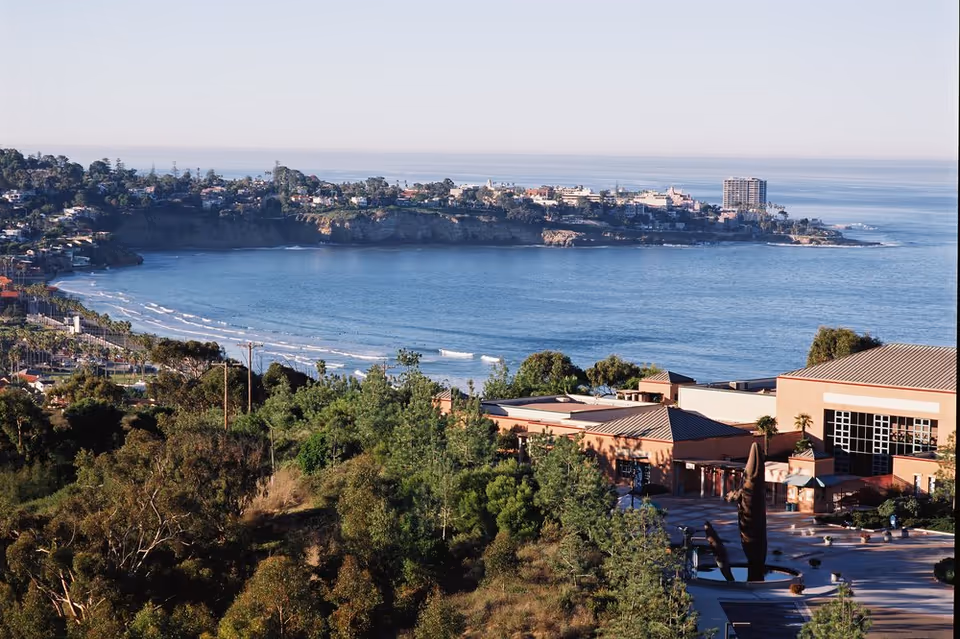 Coastal hillside nursing home campus with ocean view and greenery.