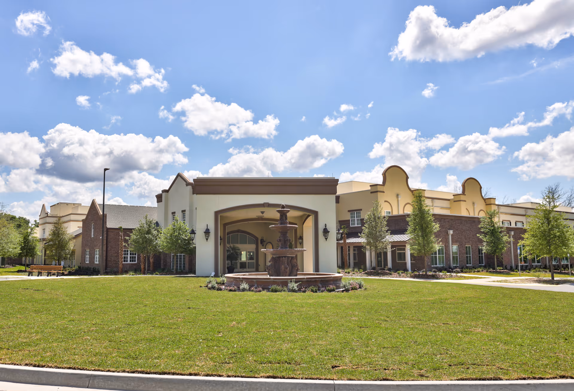 Exterior view of Dolphin Pointe Health Care with fountain and manicured lawn.