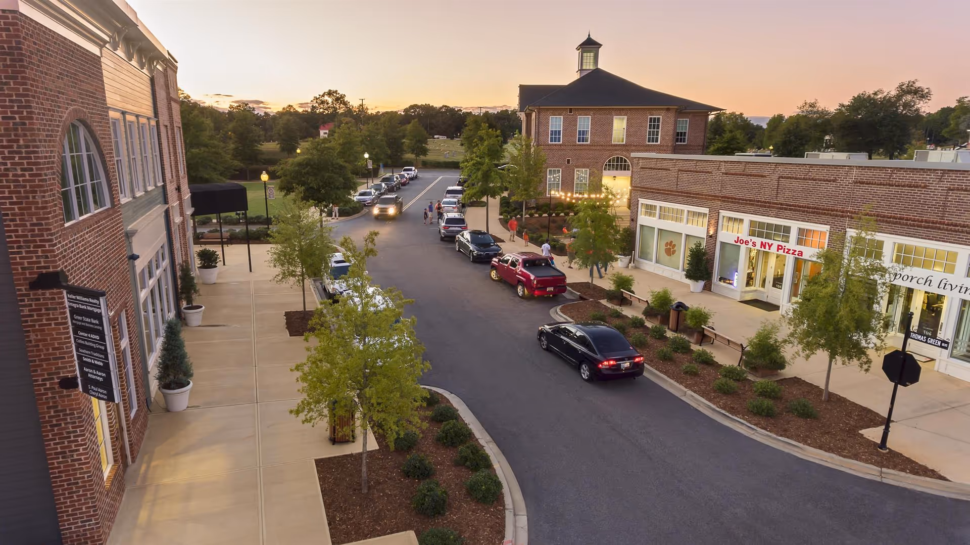 Aerial view of Home Matters Caregiving - Clemson campus street with storefronts and parked cars.