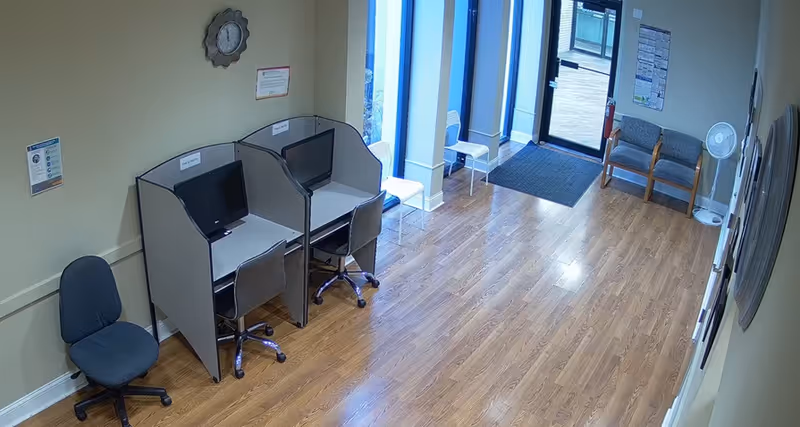 Interior room with cubicle computer stations, chairs, and a seating area.