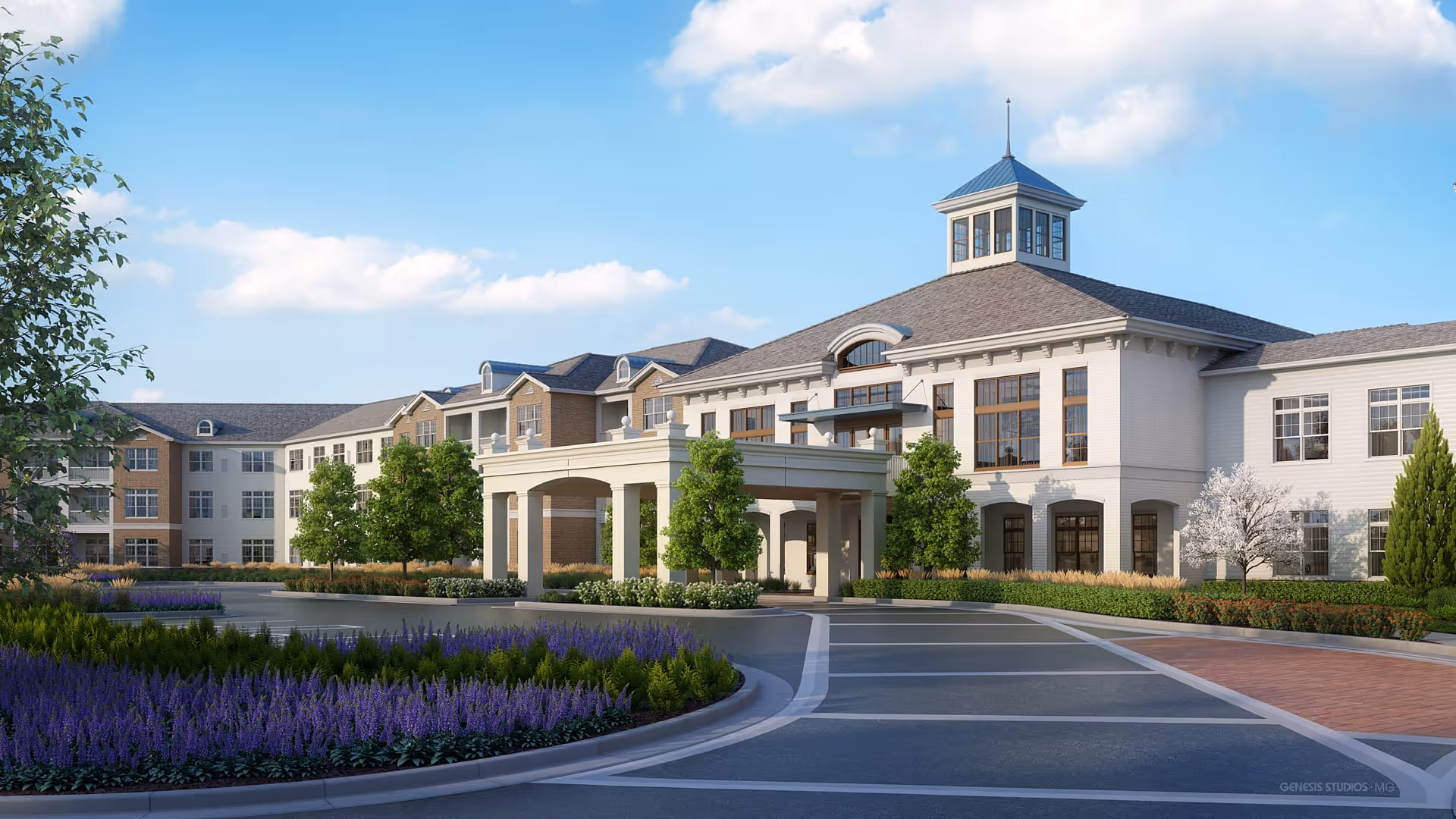 Exterior view of a large, elegant senior living facility building with a covered entrance, surrounded by landscaped gardens with purple flowers, green shrubs, and trees under a blue sky with some clouds.