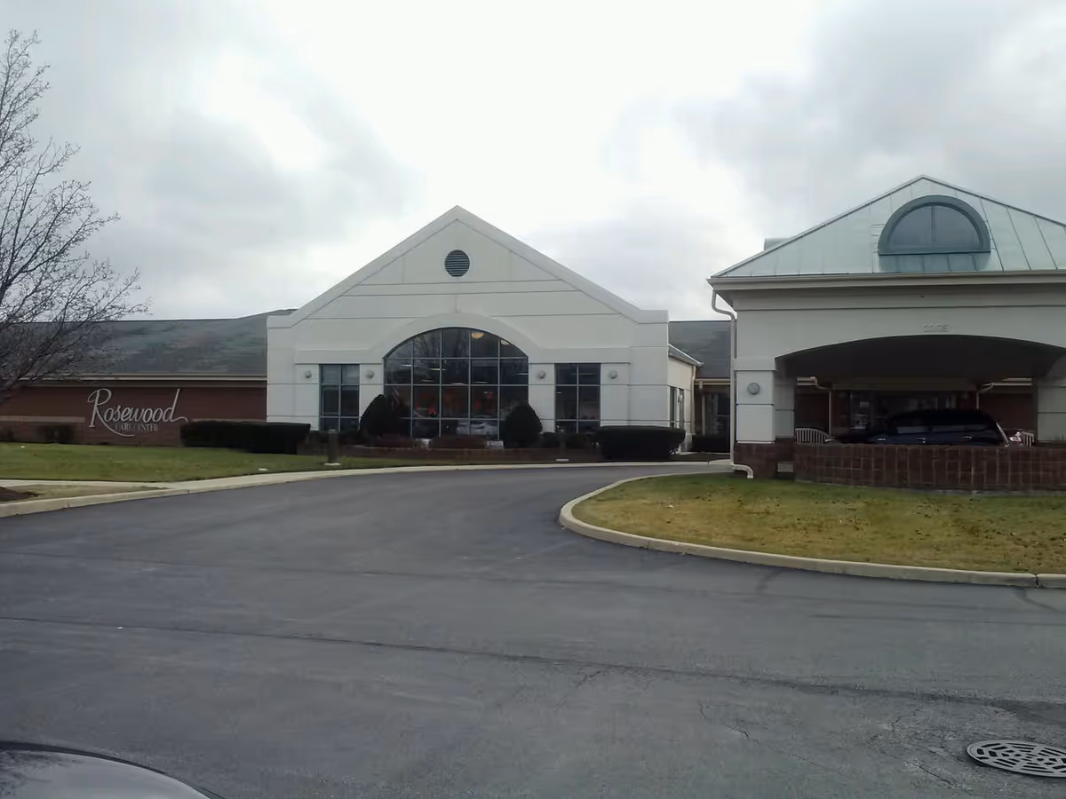 Exterior of a senior living facility with a circular driveway and arched front entrance.