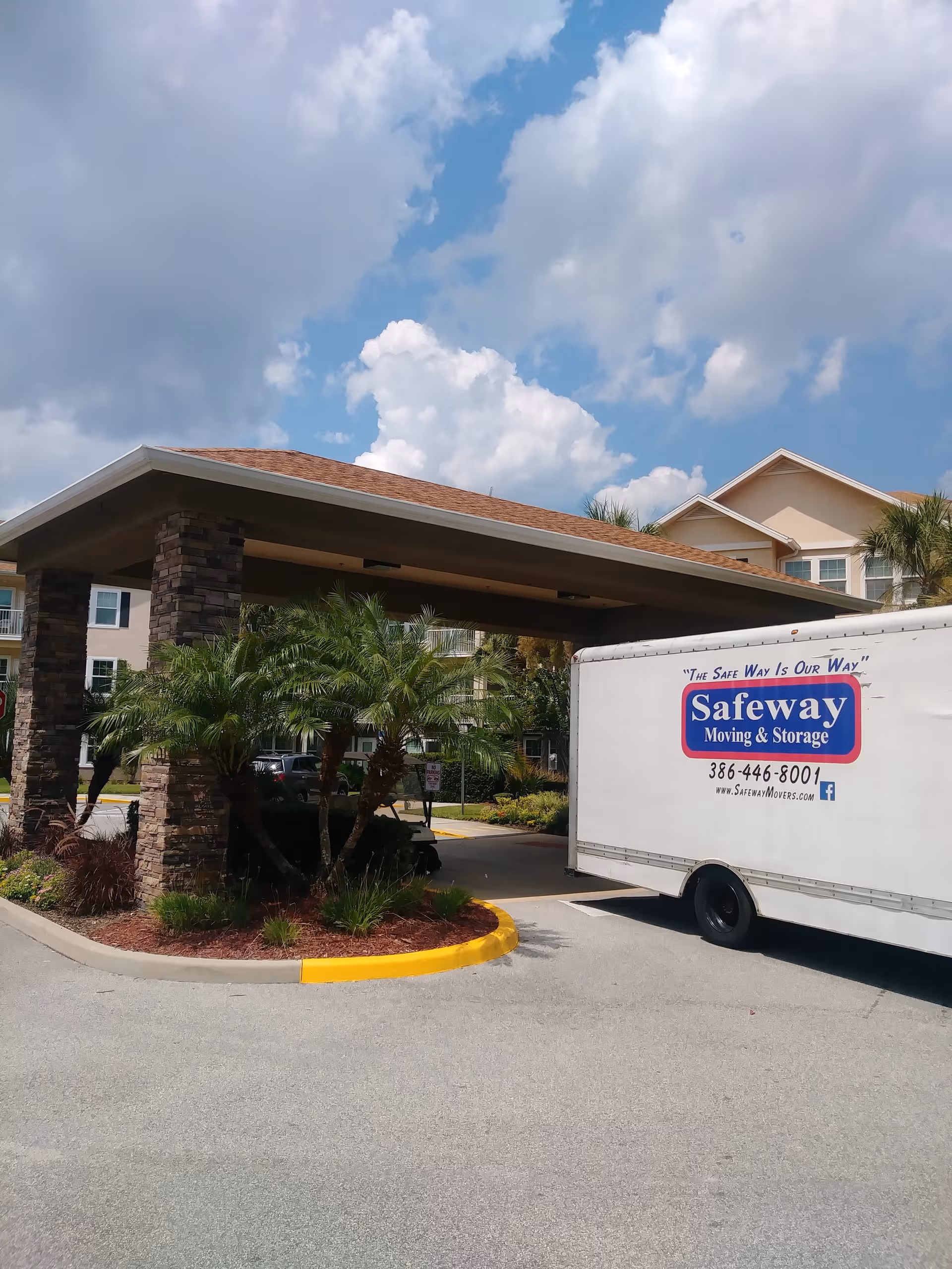 Exterior view of Las Palmas - Sky Active Living with porte-cochère and a moving truck.