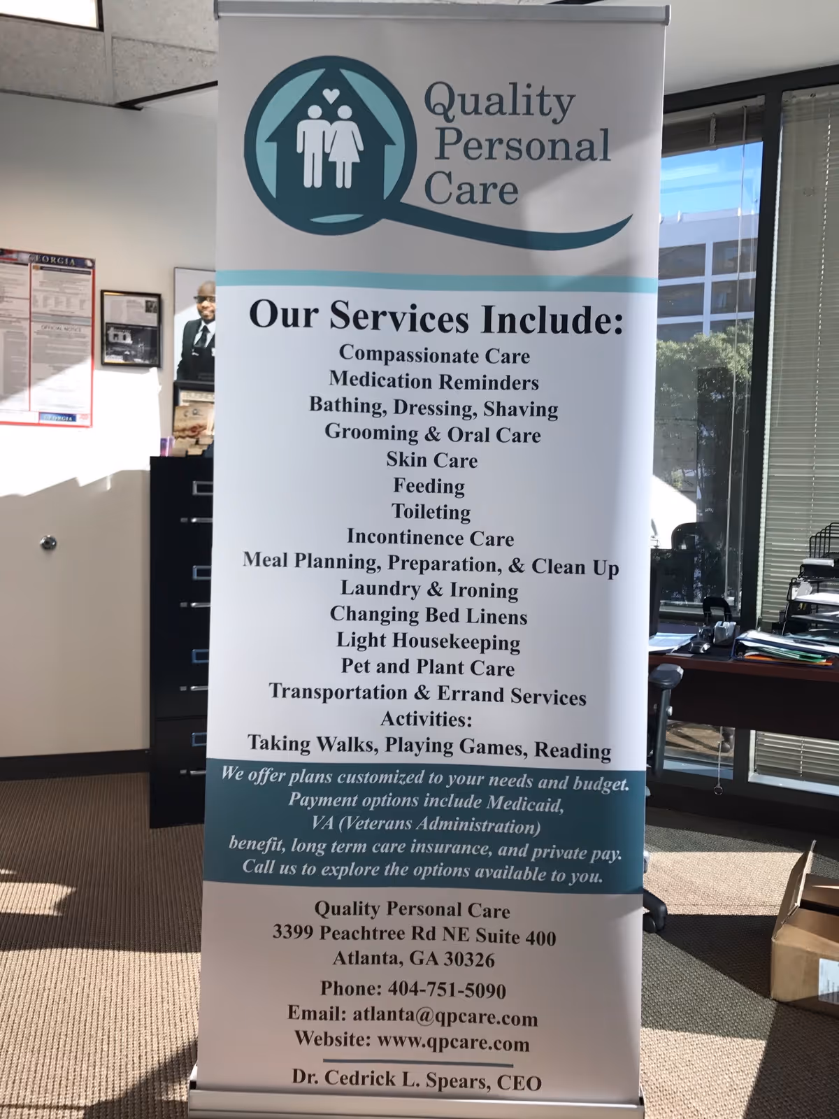 Roll-up banner displaying Quality Personal Care services in an office lobby.
