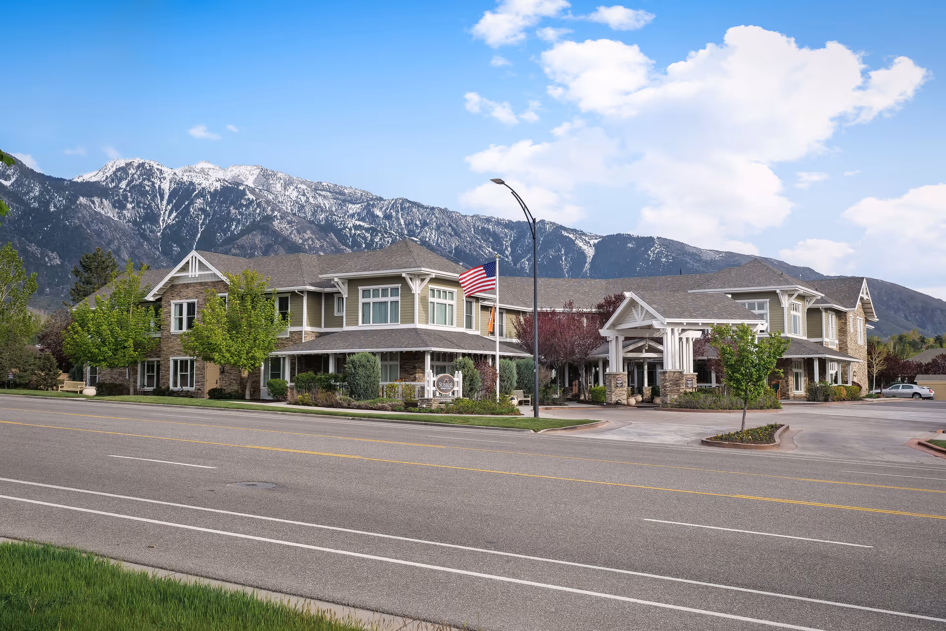Exterior view of Sunrise of Sandy senior living campus with mountains in the background.