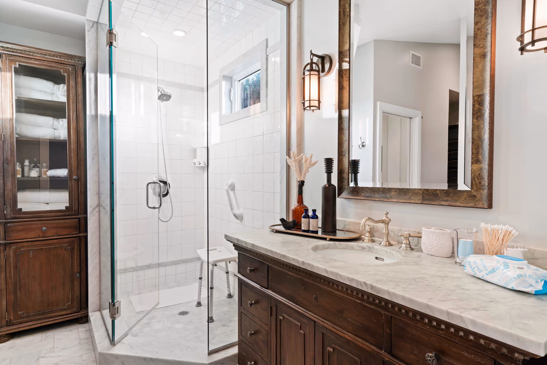 Modern bathroom featuring a glass shower, marble countertop vanity, and dark wood cabinetry.
