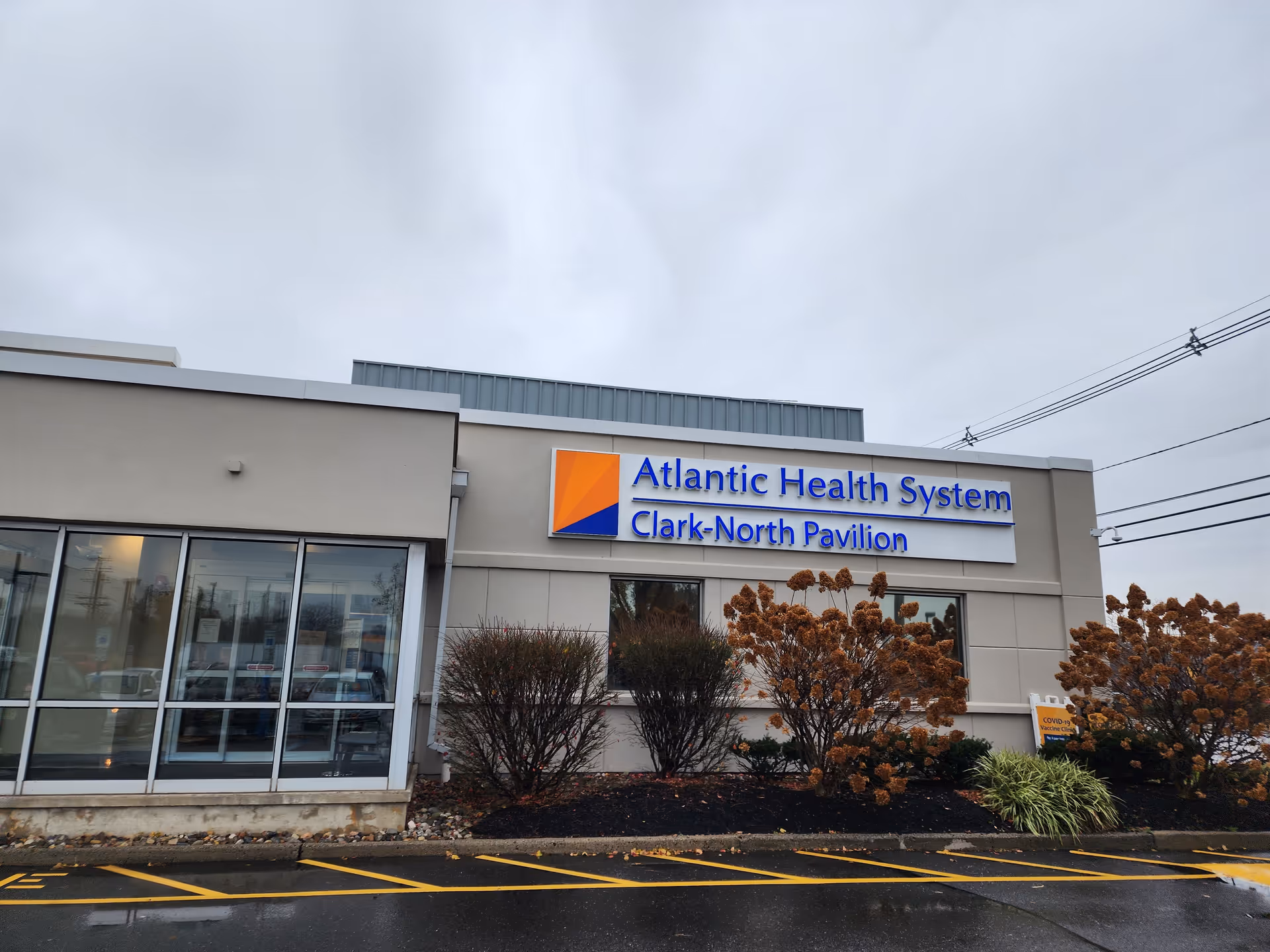 Exterior view of Atlantic Health System Clark-North Pavilion with glass entrance and signage.
