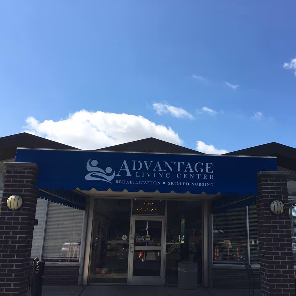 Front entrance of Advantage Living Center with blue awning and glass doors.