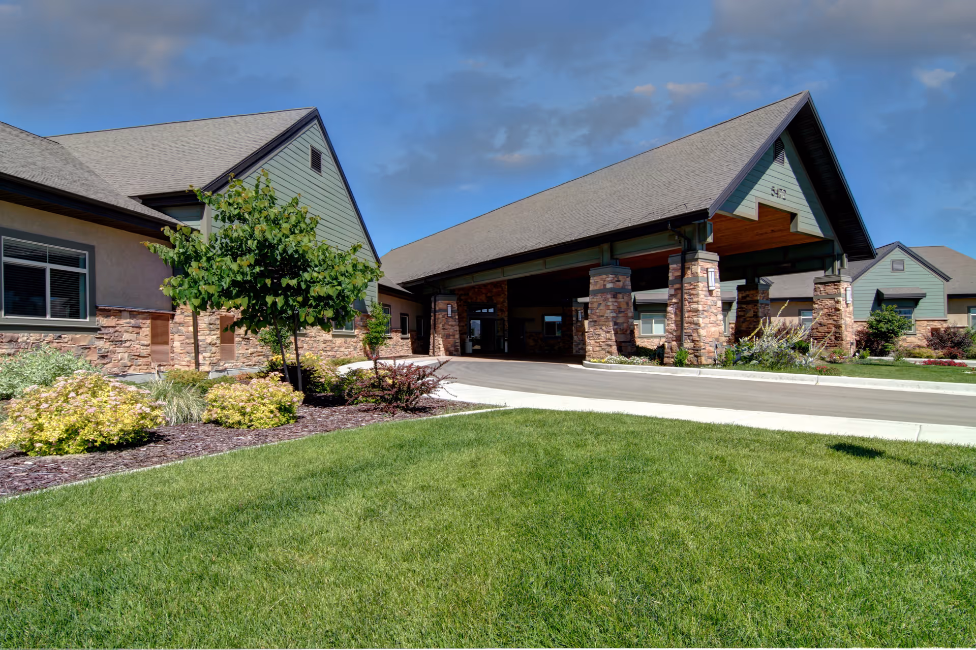 Exterior view of Legacy Village of Taylorsville with a covered entrance and landscaped lawn.