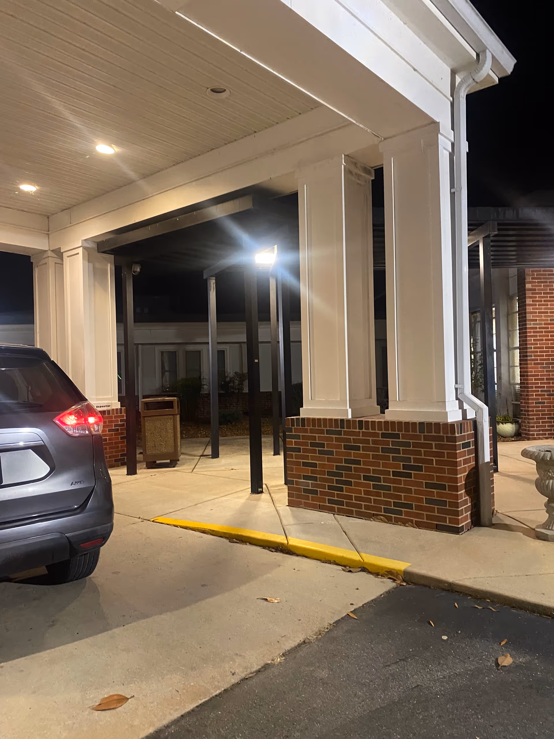 Nighttime view of the facility's front entrance with a covered drive area.