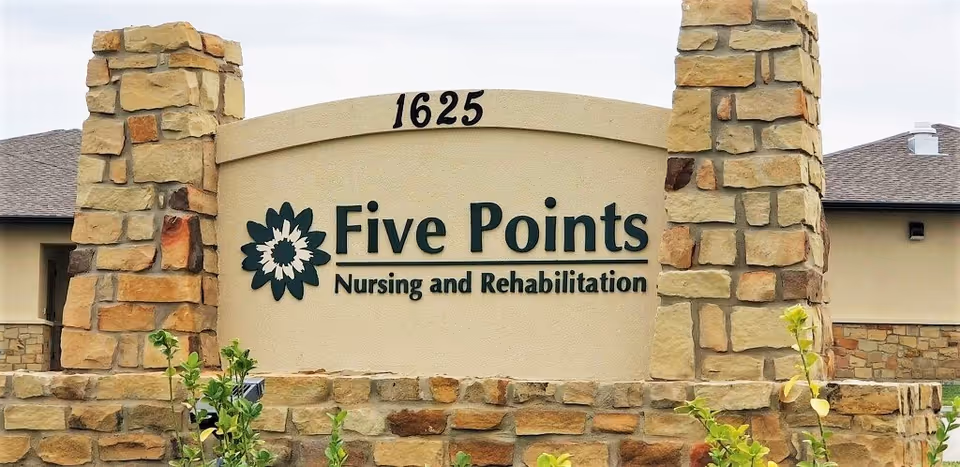 Stone entrance sign reading Five Points Nursing and Rehabilitation in front of a building.
