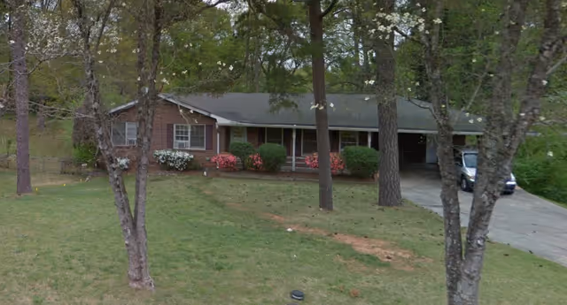 Front view of K&W Care Homes building with driveway, trees, and shrubs