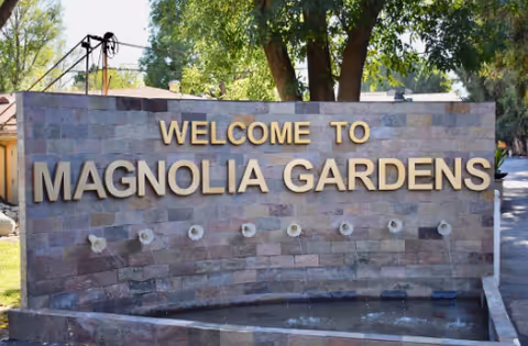 Stone entrance sign reads Welcome to Magnolia Gardens Convalescent Hospital.